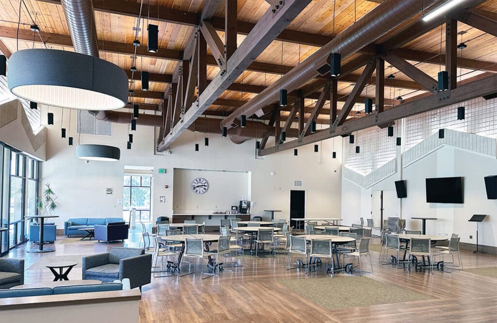 Spacious interior with seating, tables, and large screens, ideal for gatherings.