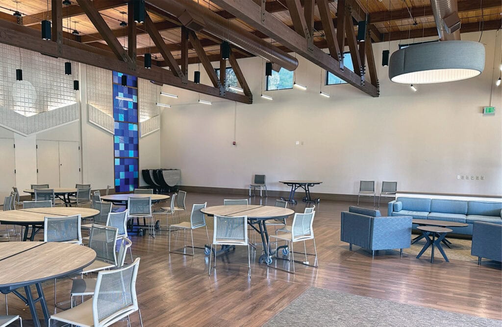 Bright interior with comfortable seating, tables, and a spacious open layout for community events and activities.