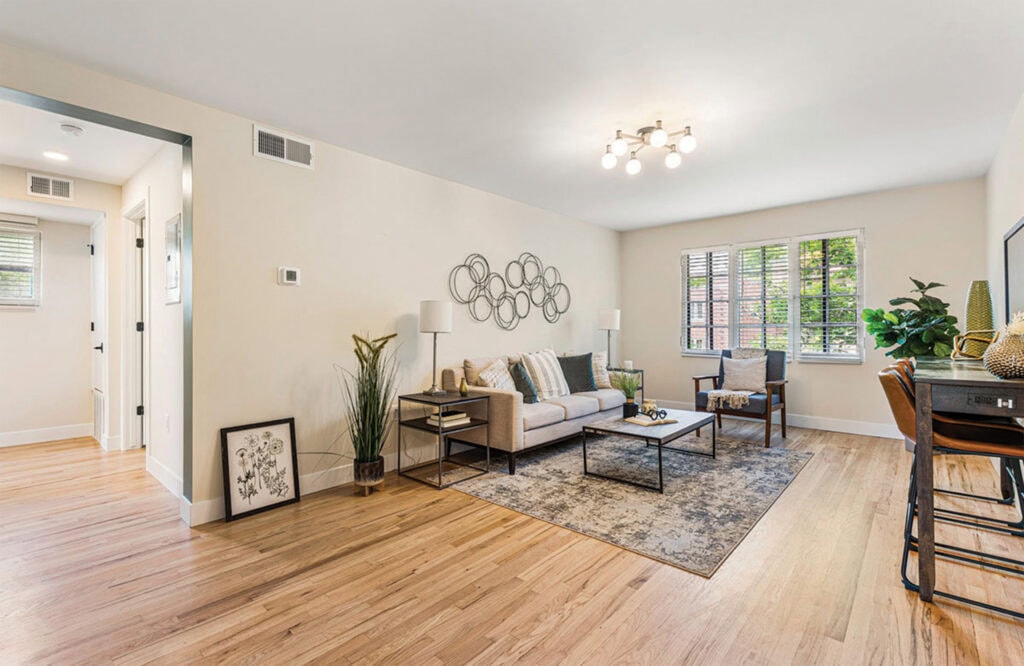 Bright living space featuring neutral tones, stylish furniture, and lush greenery.