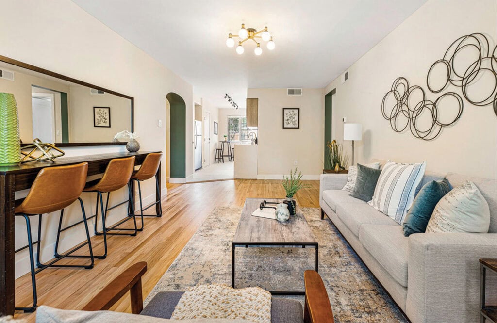 Bright, inviting living space featuring a comfortable sofa, contemporary wall art, and hardwood floors.