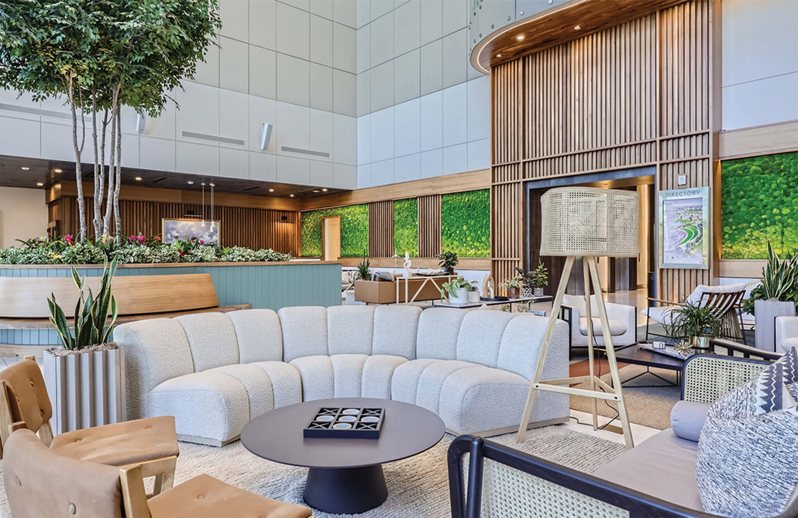Bright, inviting hotel lobby with contemporary design, wooden accents, and greenery.