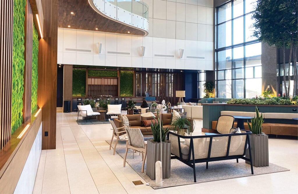 Bright hotel lounge interior with natural light, modern décor, and green plants, perfect for relaxation.
