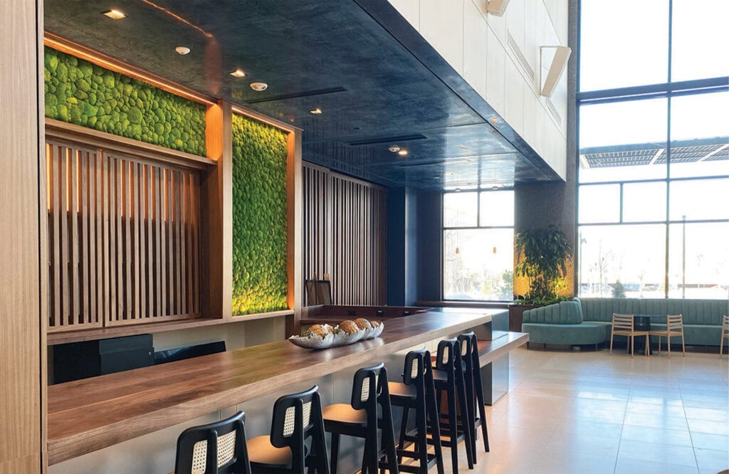 Bright hotel lounge featuring green wall accents and spacious seating area.
