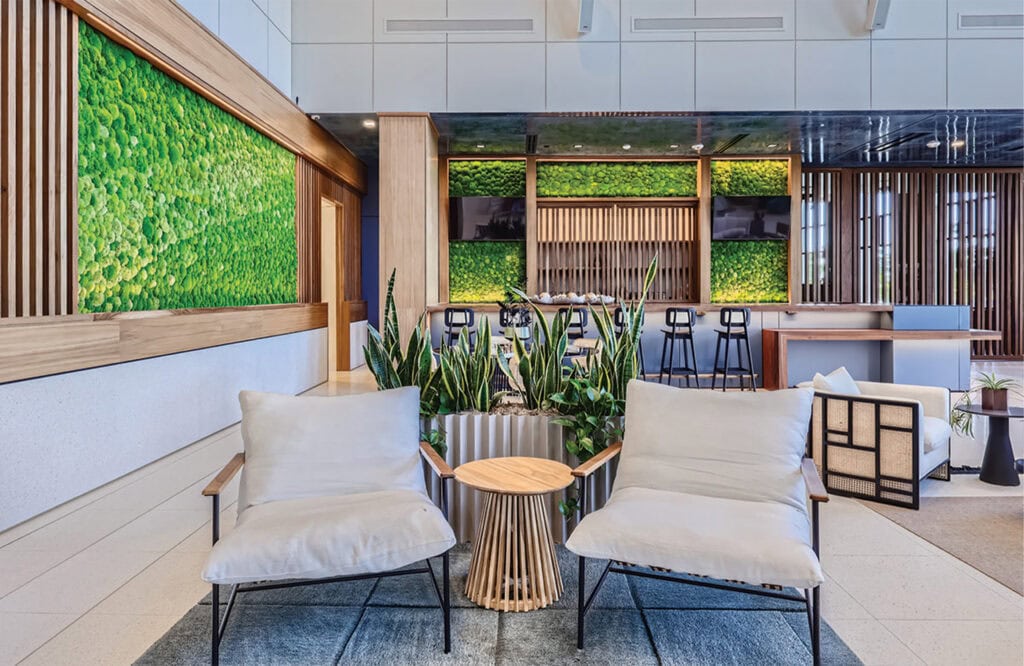Luxurious hotel lobby featuring green moss walls, contemporary furniture, and natural wood accents.